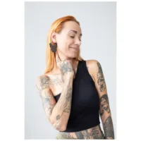 Nainen mustilla Bulldog Hoops -korvakoruilla vaaleaa taustaa vasten