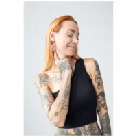 Nainen, jolla on tatuoidut käsivarret, käyttää Bulldog Hoops ruusukullassa