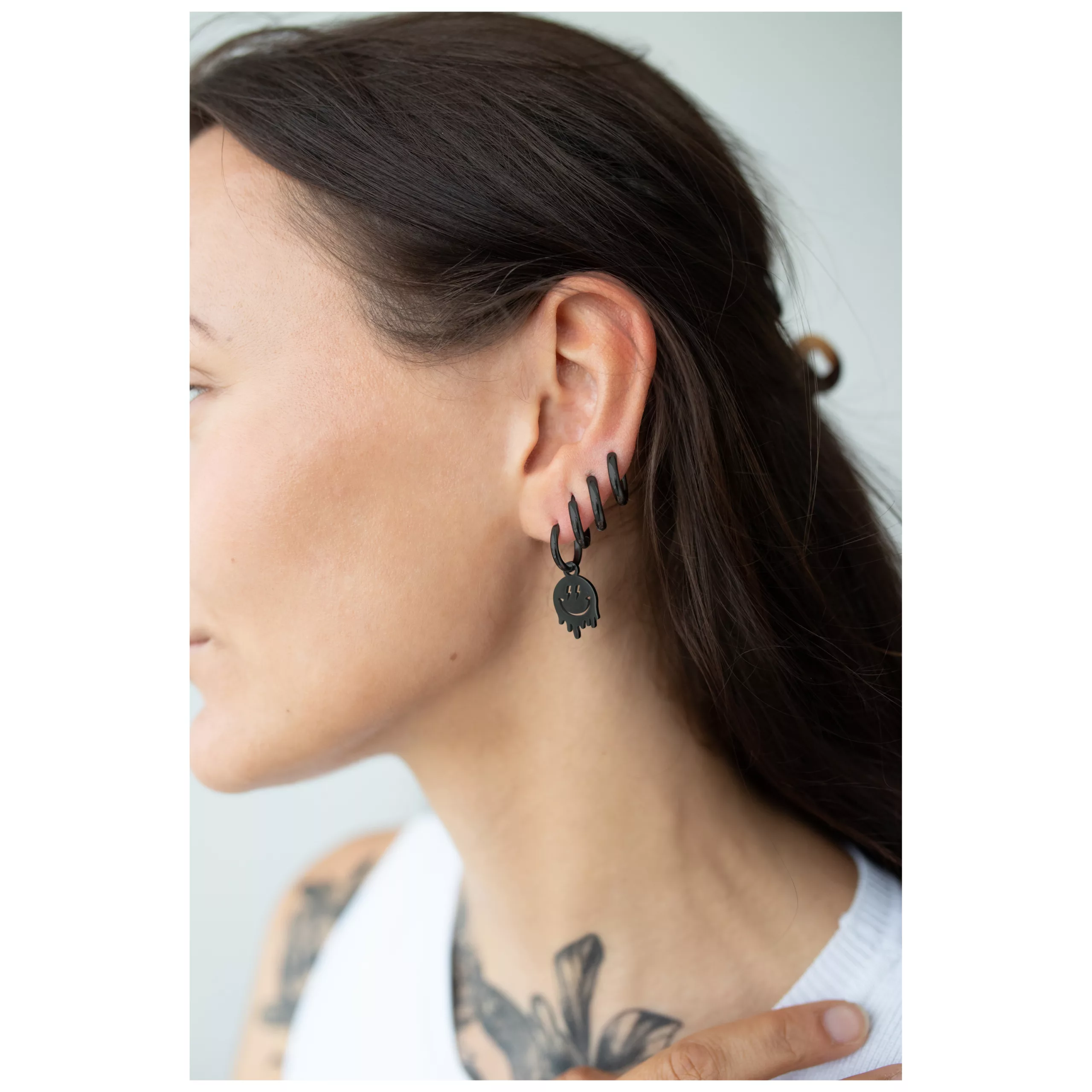 Musta Little Smiley Hoops korvassa Nainen mustilla Little Smiley Hoops korvakoruilla kirurginteräksestä