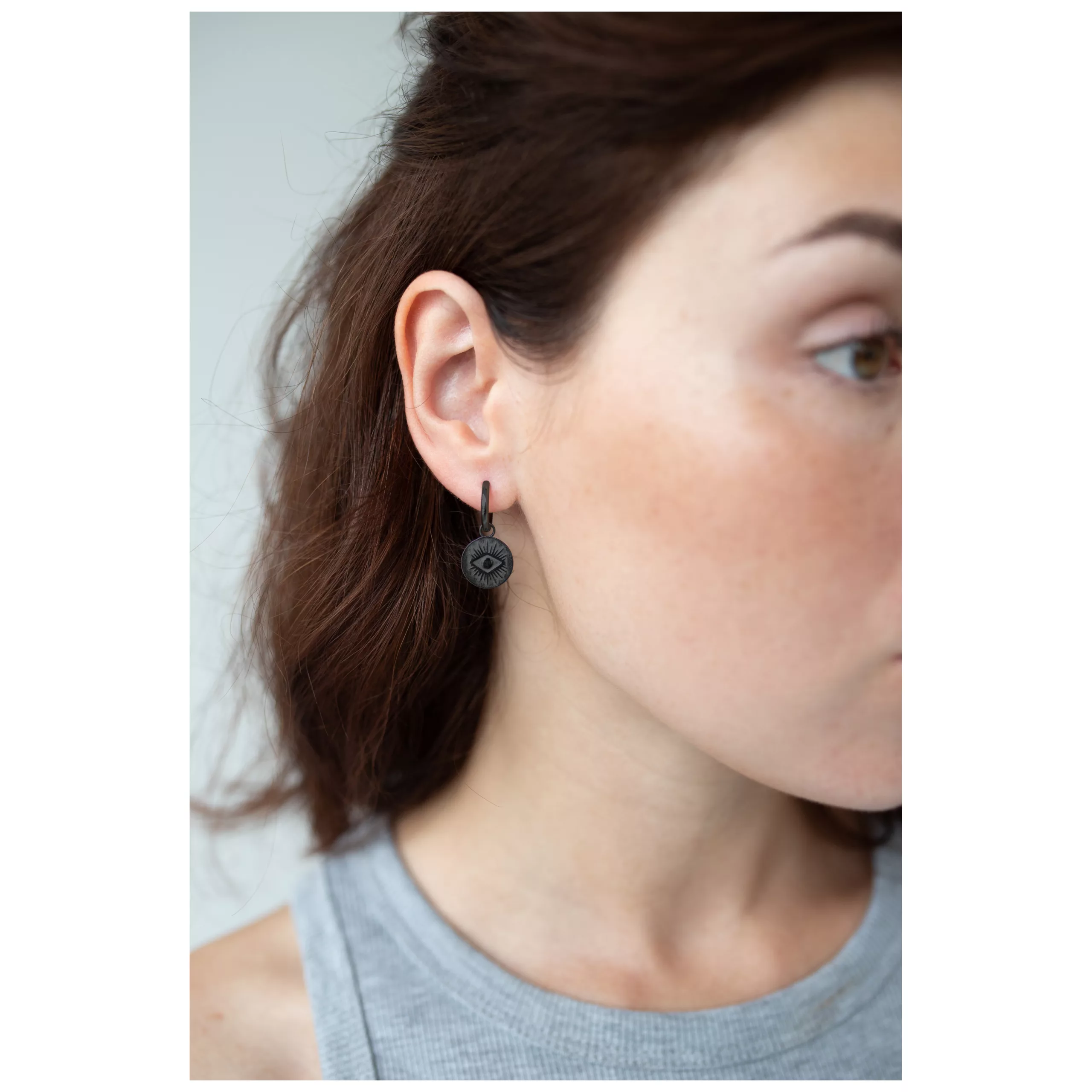 Musta korvarenkaat silmäkuviolla henkilön korvassa, lähikuva