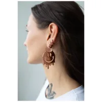 Nainen käyttää suuria ruusukultaisia Smiley-korvakoruja kirurginteräksestä