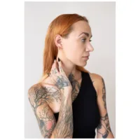 Nainen kultaisilla Little Bar Hoops -korvakoruilla, sivuprofiili