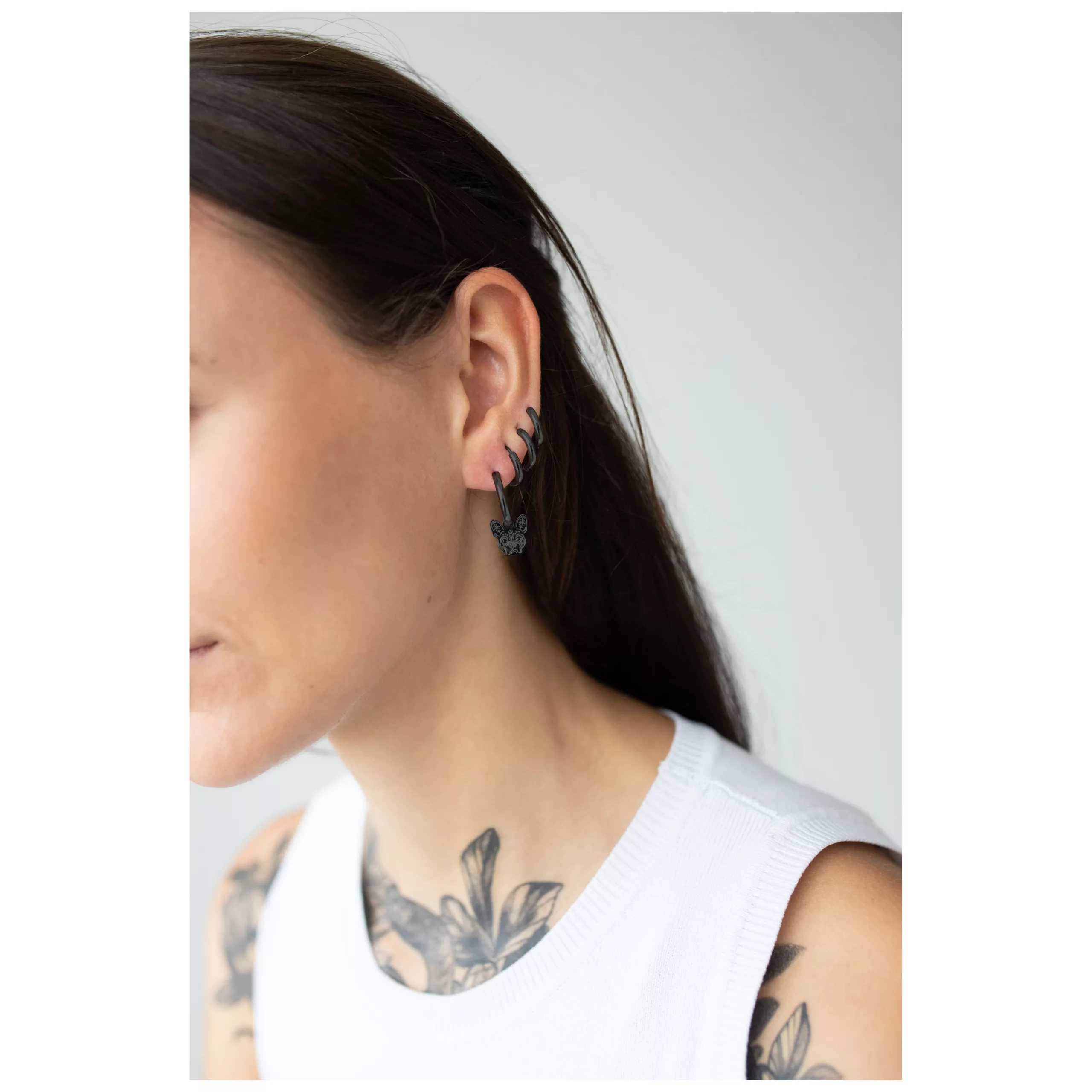 Nainen mustilla Little Bulldog Hoops korvakoruilla kirurginteräksestä