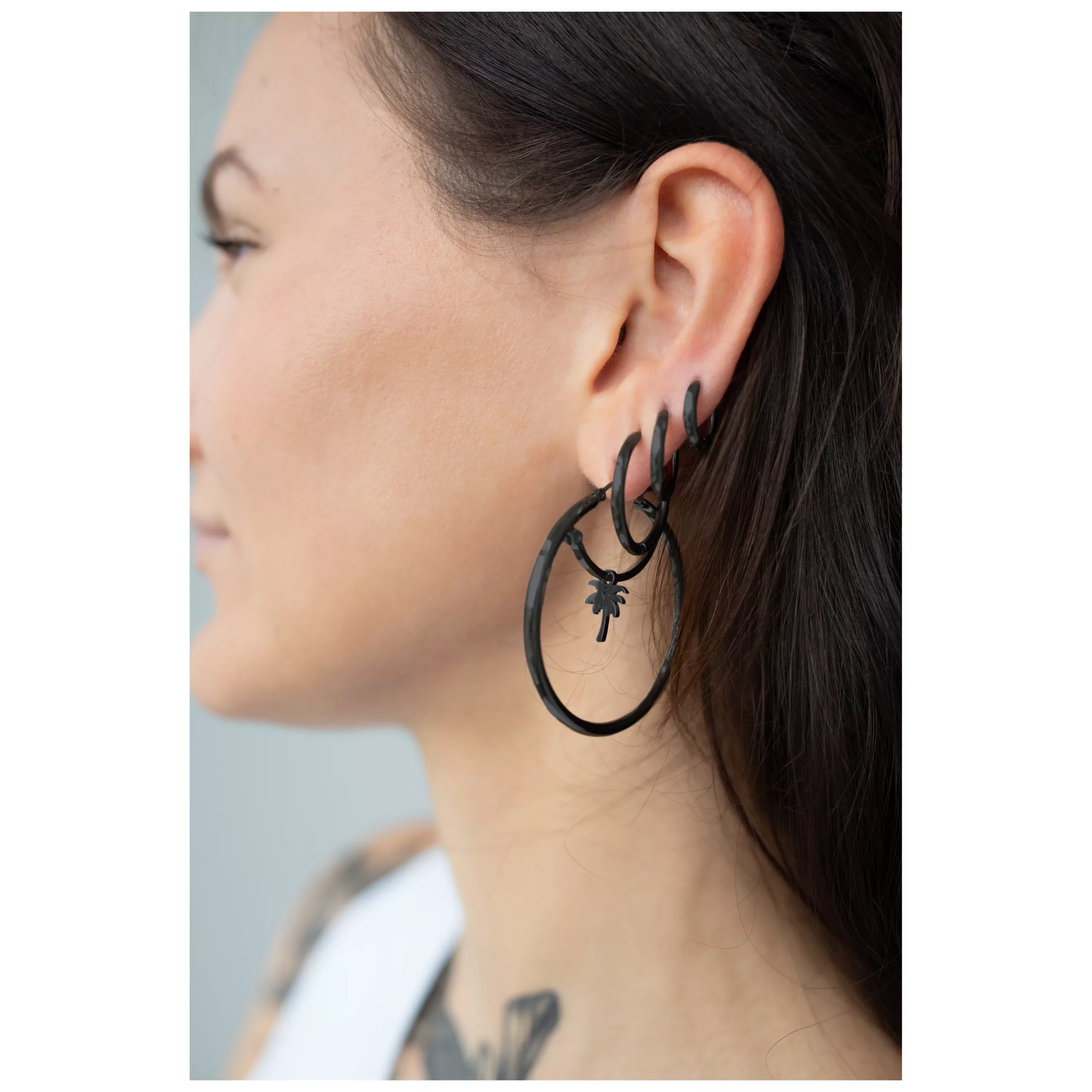 Musta kirurginteräksestä valmistettu korvakoru korvassa