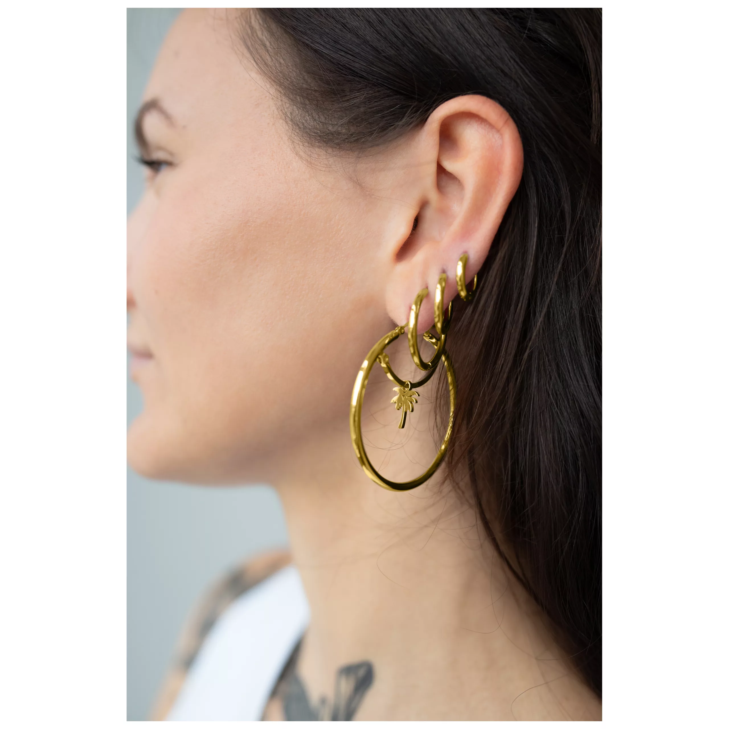 Kultaiset perusrenkaat klipsilukolla Kultaiset renkaat klipsilukolla naisen korvassa, kiiltävät