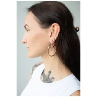 Ruusuhopeat korvakorut klipsilukolla, tummatukkaisen naisen profiilissa