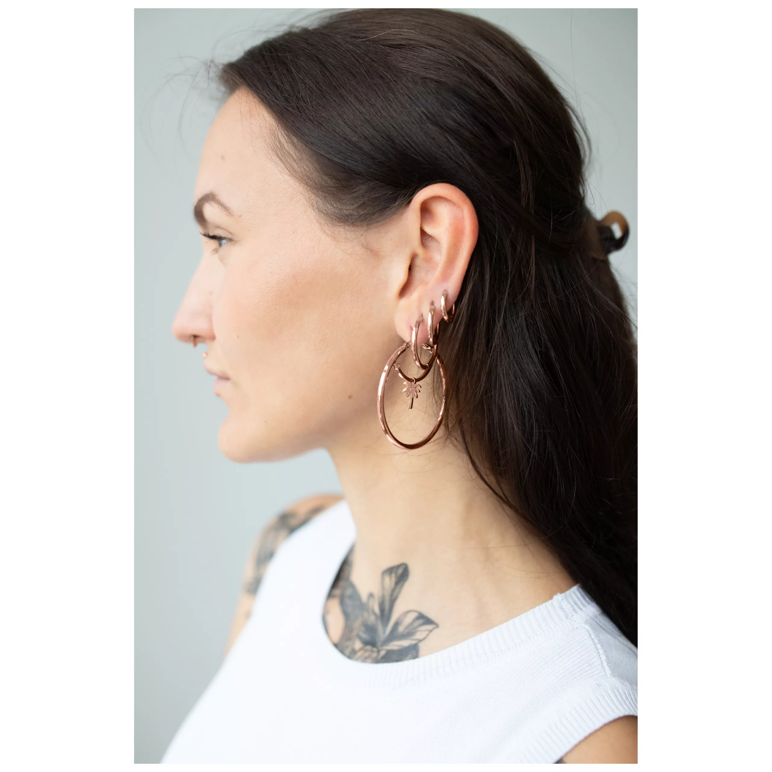 Ruusuhopeat korvakorut klipsilukolla, tummatukkaisen naisen profiilissa