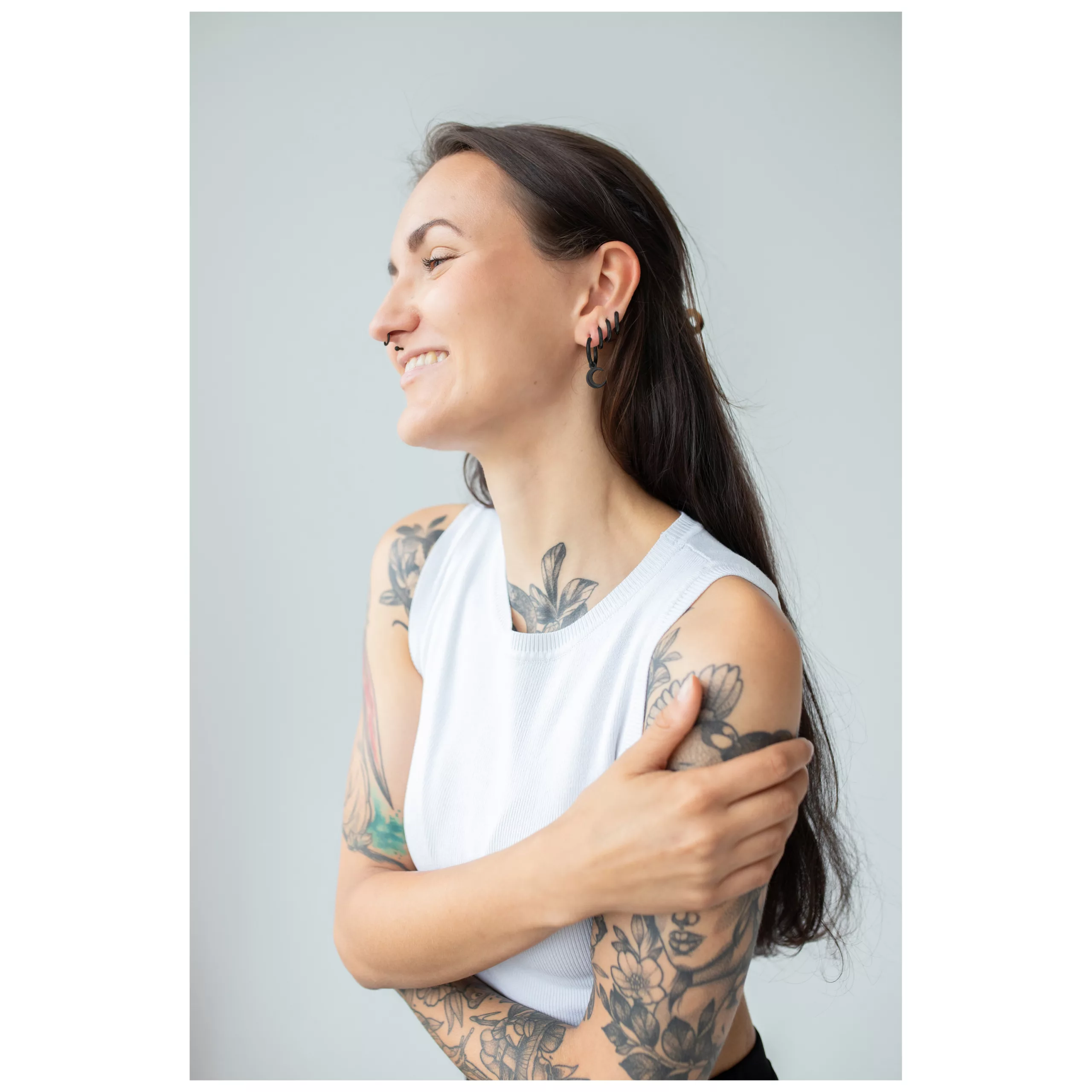 Tatuoitu nainen käyttää mustia Little Moonchild Hoops -korvakoruja