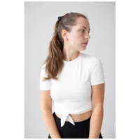 Pitkähiuksinen nainen käyttää kultaisia Little Cross Hoops -korvakoruja