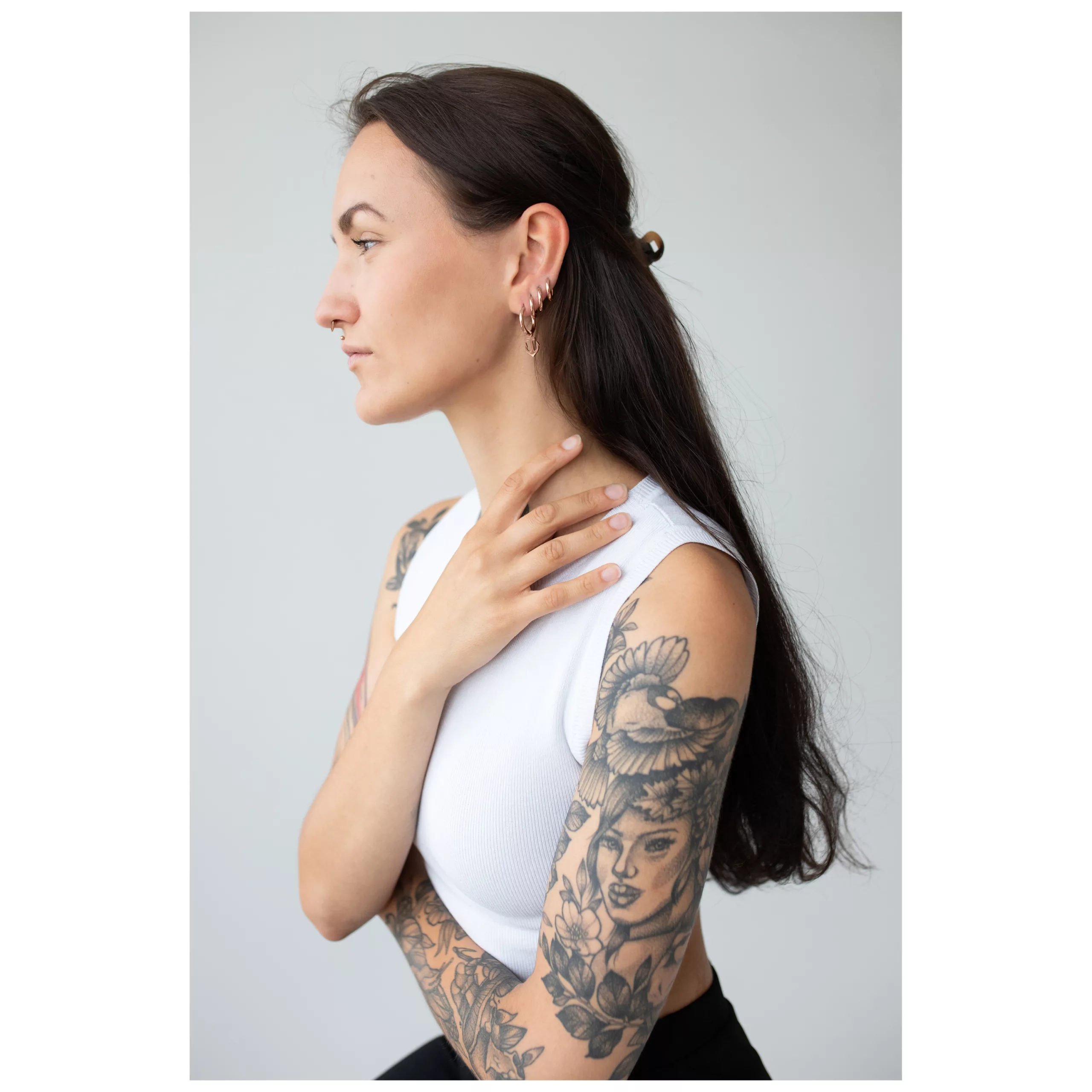 Pitkähiuksinen nainen käyttää ruusuhopeita Little Anchor Hoops -korvakoruja