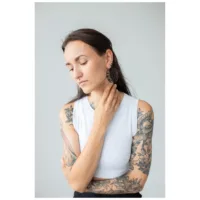 Nainen, jolla on tatuoidut käsivarret, käyttää mustia Moon Eclipse Hoops -korvakoruja