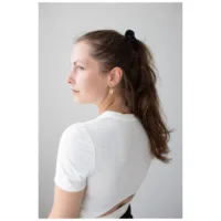 Nainen Little Lock Hoops kultakorvakoruilla, valkoinen paita, musta hiuspanta