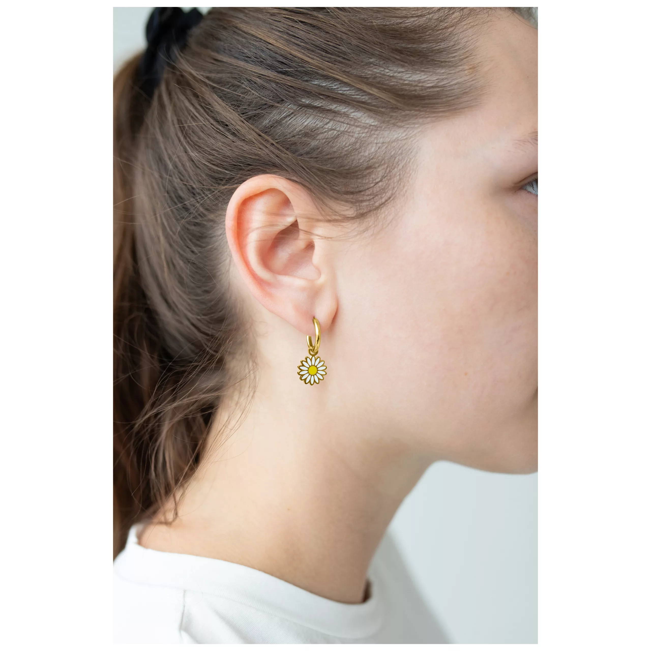 Kultaiset Little Daisy Hoops -korvakorut Nainen kultaisilla Little Daisy Hoops -korvakoruilla, sivuprofiili