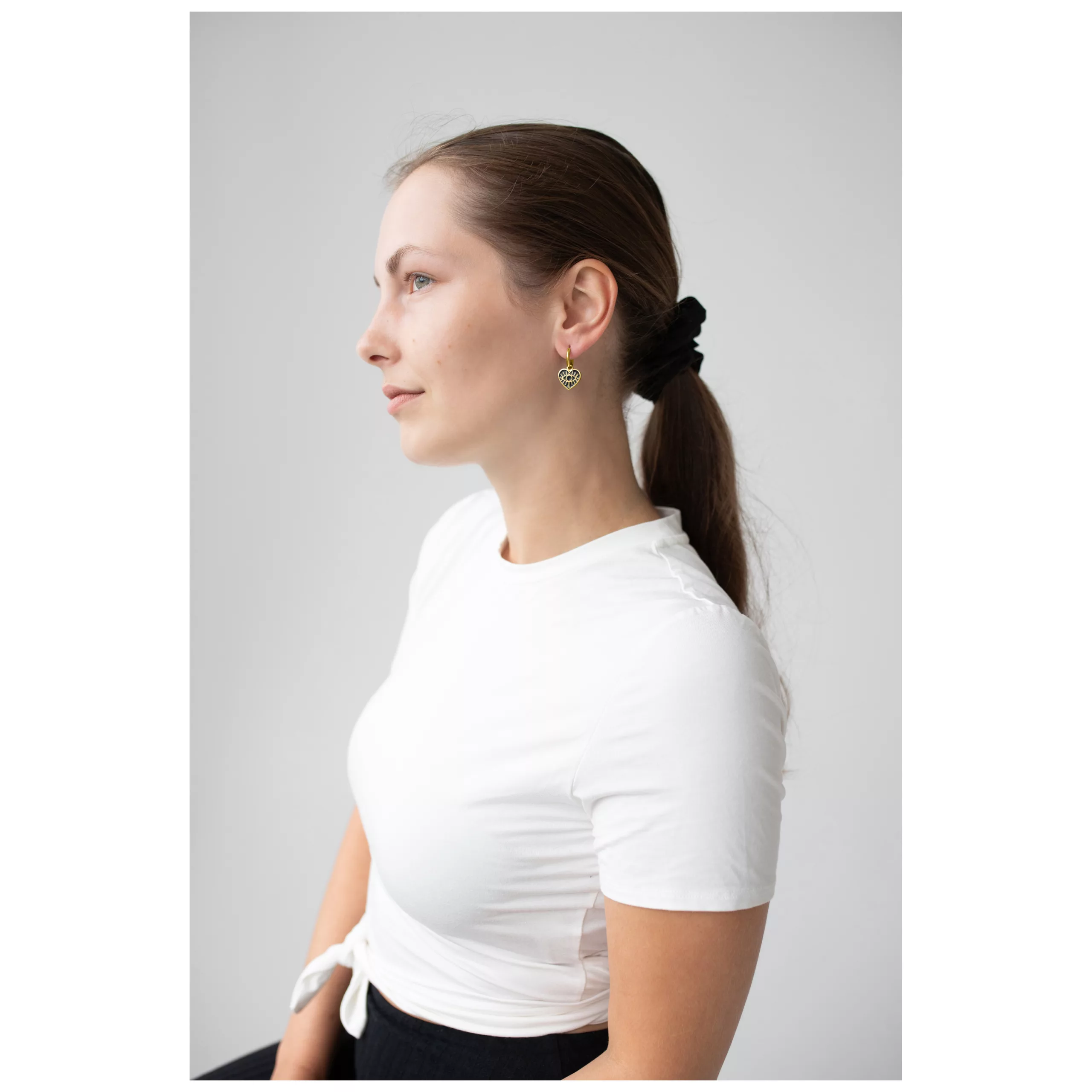 Nainen Little Soulmate Hoops -korvakoruilla kultaisessa metallivärissä, sivuprofiili