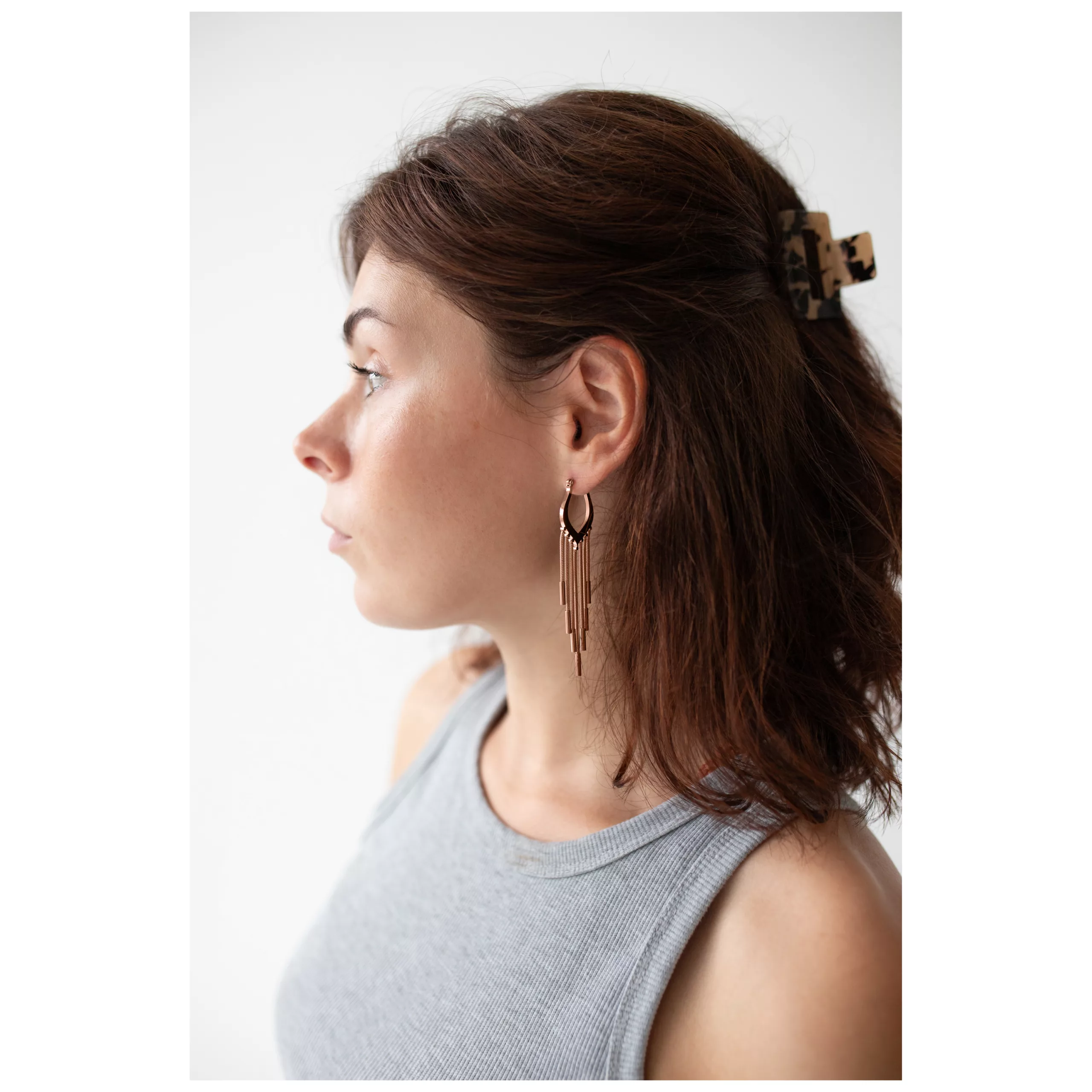 Nainen ruusuhopeisilla Snakechain Hoops -korvakoruilla sivulta valkoisella taustalla