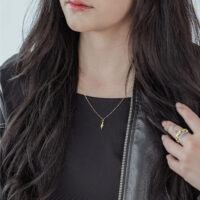 Frau mit goldener Little Snake Kette, schwarzes Outfit, lange Haare