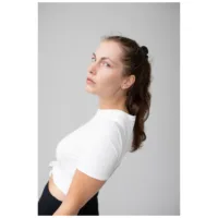 Malli käyttää ruusu-kultaisia Crystal Square korvakoruja harmaata taustaa vasten