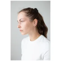 Nainen kultaisilla Double Beam Crystal -korvakoruilla neutraalilla taustalla