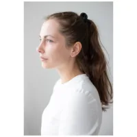 Kultaiset Crystal Lightning -korvakorut Nainen kultaisilla Crystal Lightning -korvakoruilla, sivulta