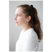 Nainen ruusuhopeisilla Crystal Lightning -korvakoruilla valkoisella taustalla