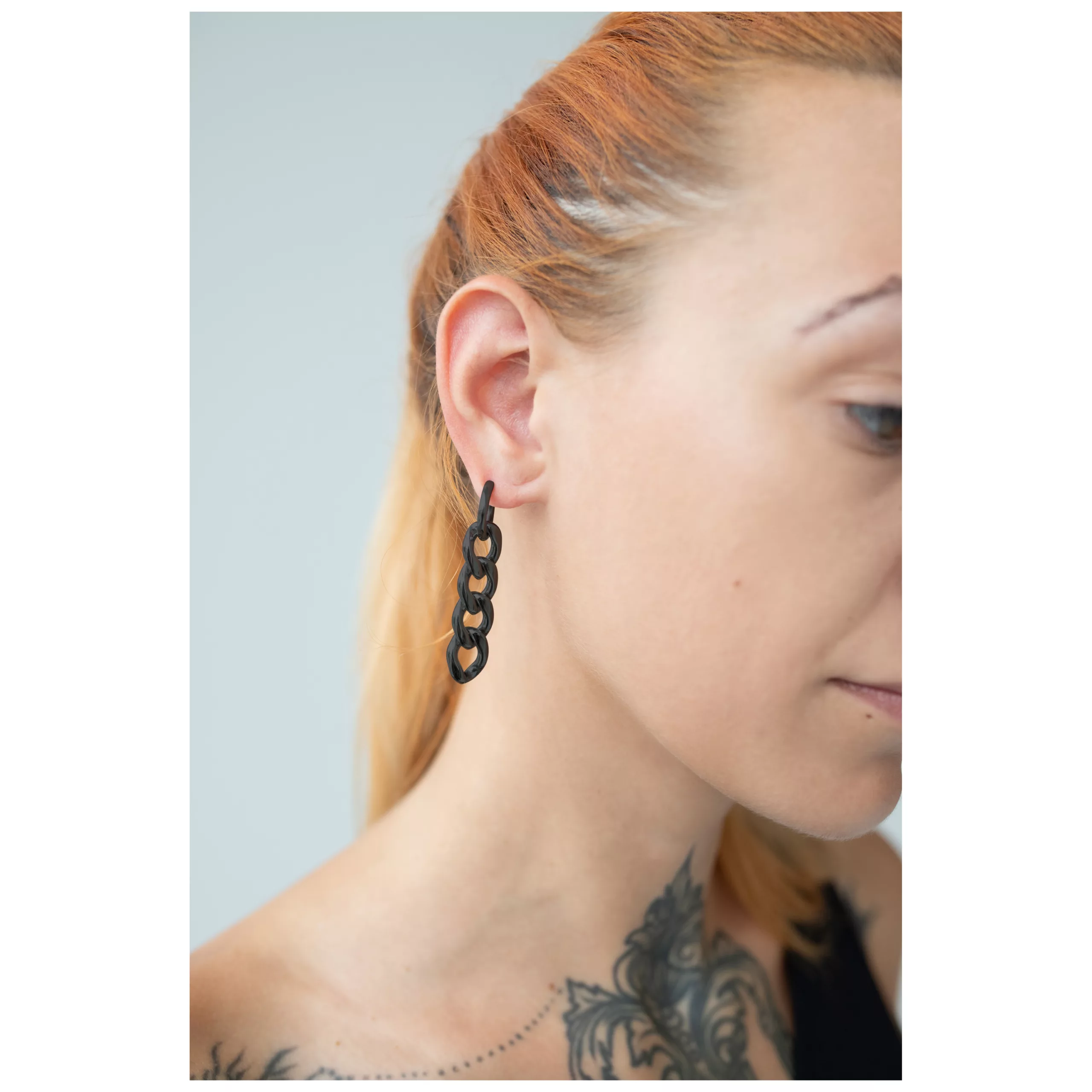 Mustat kirurginteräksiset korvakorut korvassa