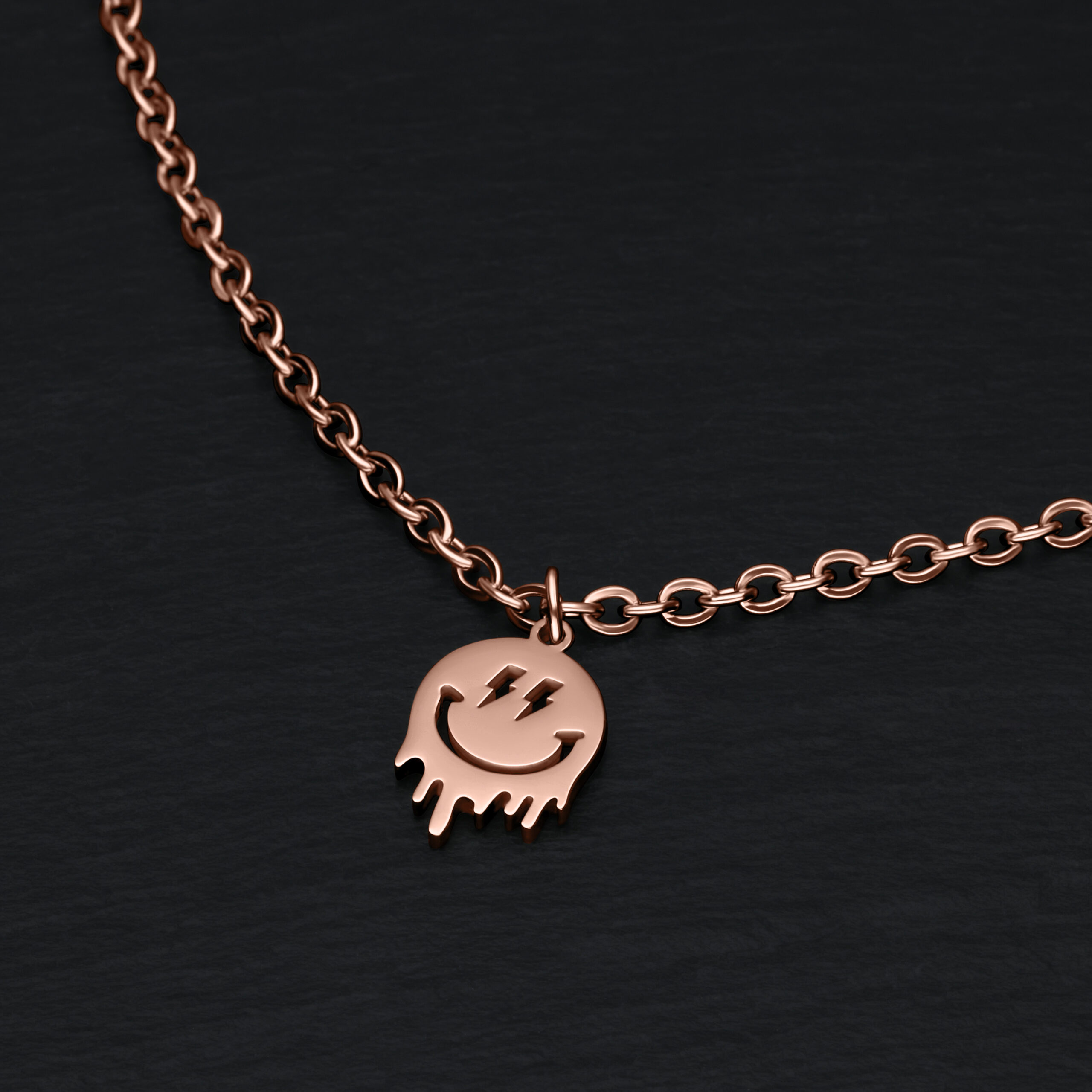 Roségoldenes Armband mit Smiley-Anhänger auf schwarzem Hintergrund