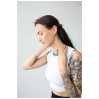 Nainen mustilla Ovaali Basic Hoops korvakoruilla vaaleaa taustaa vasten