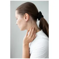 Rosékultaiset korvakorut Little 5 Rings Hoops Nainen ruskeilla hiuksilla käyttää rosékultaisia korvakoruja valkoisella taustalla