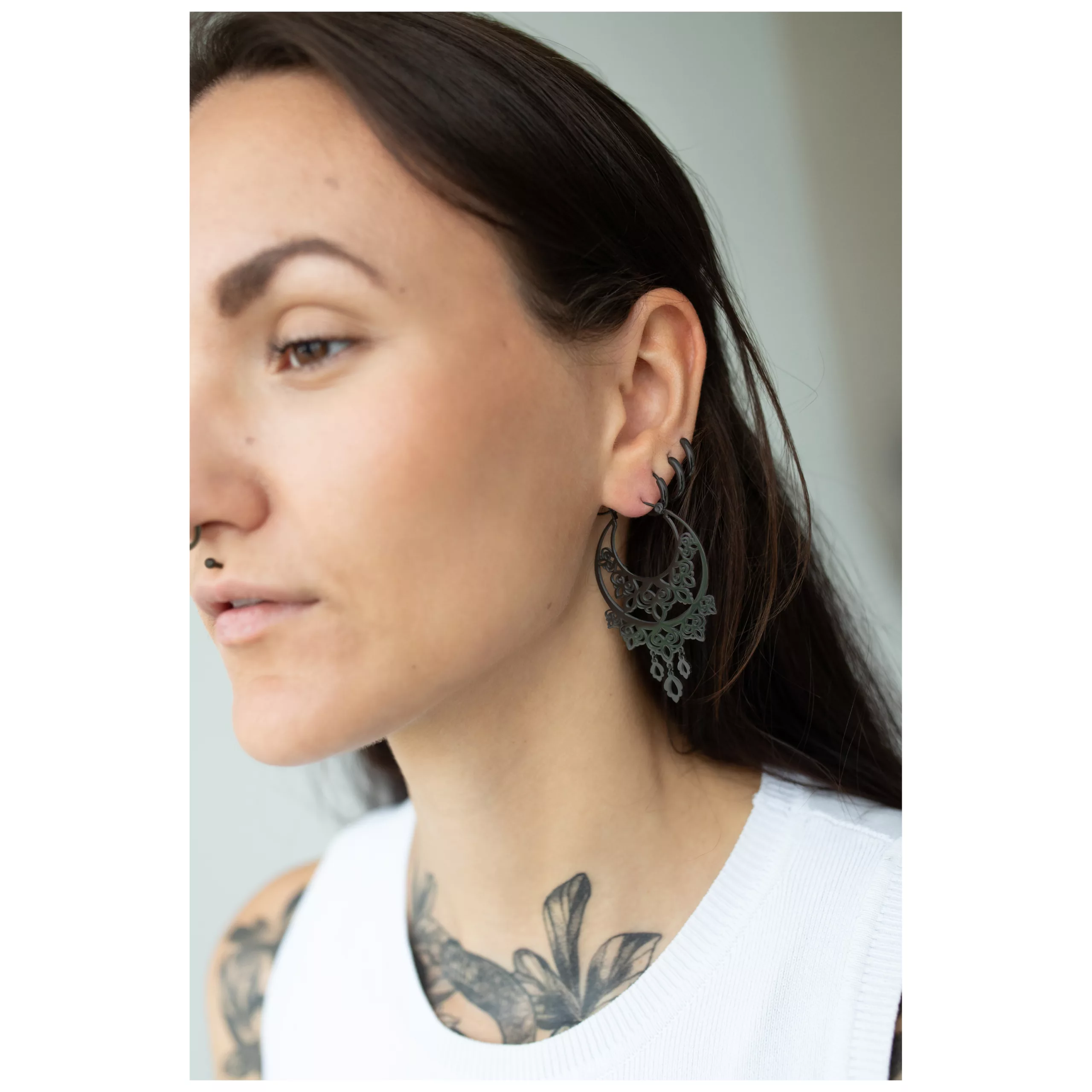 Schwarze Barock Ohrringe aus Chirurgenstahl Frau mit schwarzen Barock Ohrringen aus Chirurgenstahl, weißes Oberteil