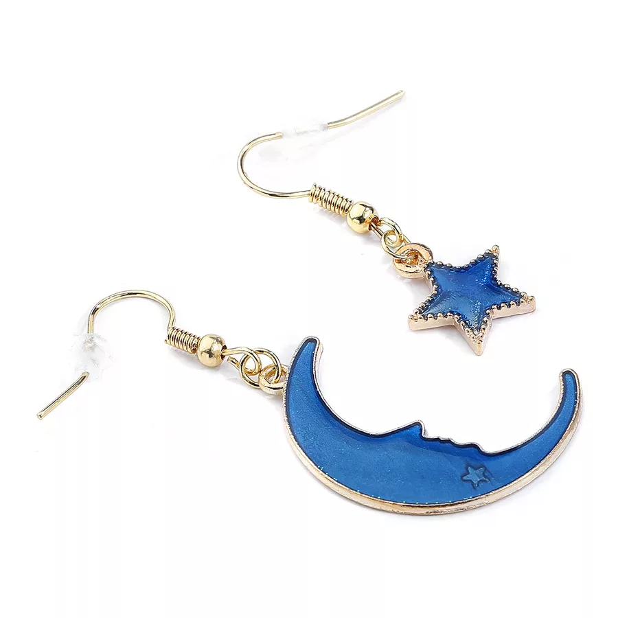 Kultaiset korvakorut kuun ja tähden designilla Kultaiset korvakorut sinisellä kuulla ja tähdellä valkoisella taustalla