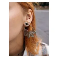 Hopeiset Abey Hoops korvakorut lehtikuviolla naisen korvassa, tausta sumea