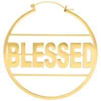 Kultaiset korvakorut, joissa teksti 'BLESSED' valkoisella taustalla