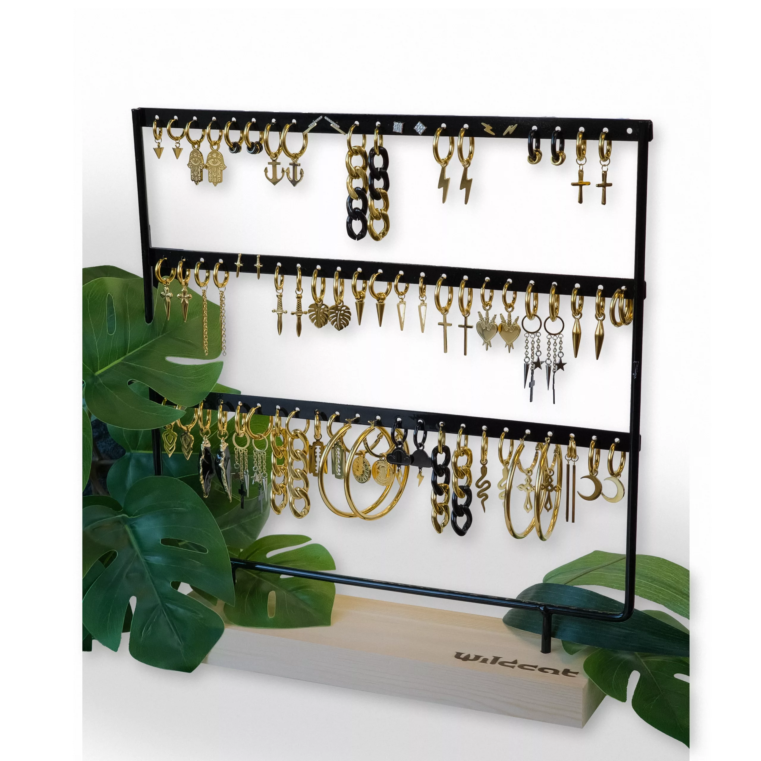 Musta Wildcat-näyttö korvakoruille, joissa on kultaisia koruja puupohjalla