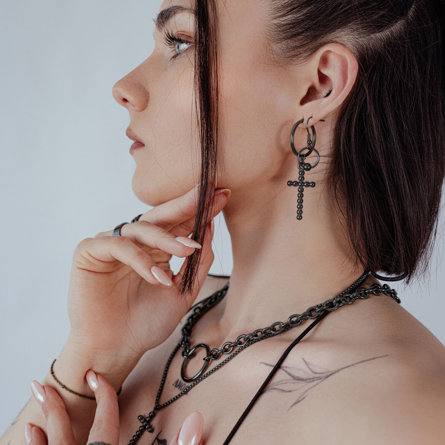 Schwarze Bubble Cross Hoops Ohrringe Frau mit schwarzen Bubble Cross Hoops Ohrringen und passender Kette