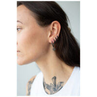 Little Polar Star Hoops - Musta Metalli Korvakorut mustasta metallista henkilön korvassa, jolla on tummat hiukset ja tatuointi