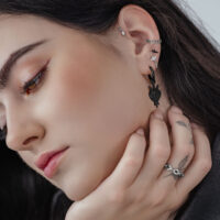 Frau mit schwarzen Herz-Schwert Creolen aus Chirurgenstahl, Nahaufnahme