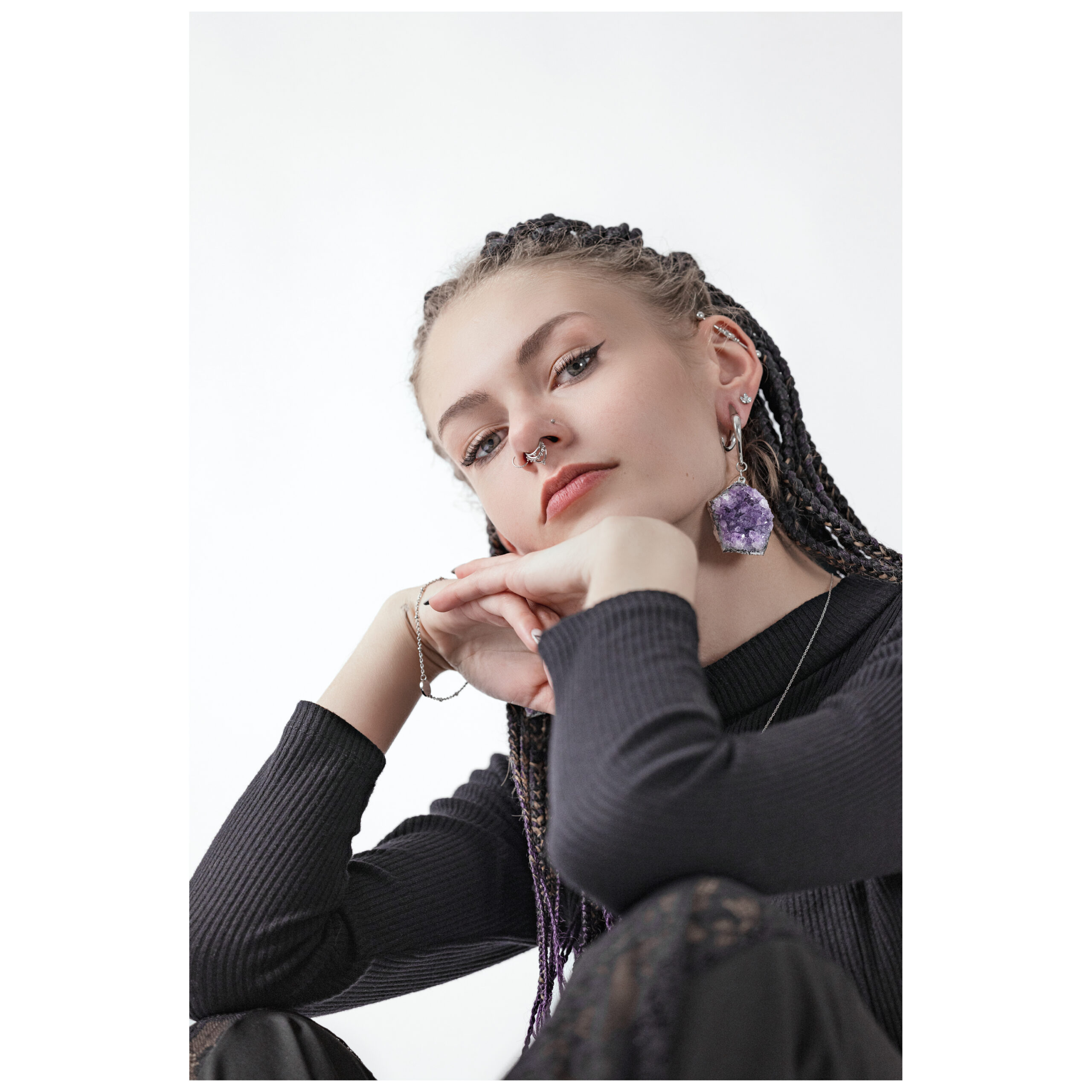 Nainen ametisti Crystals korvakorupainoilla hopeassa valkoisella taustalla