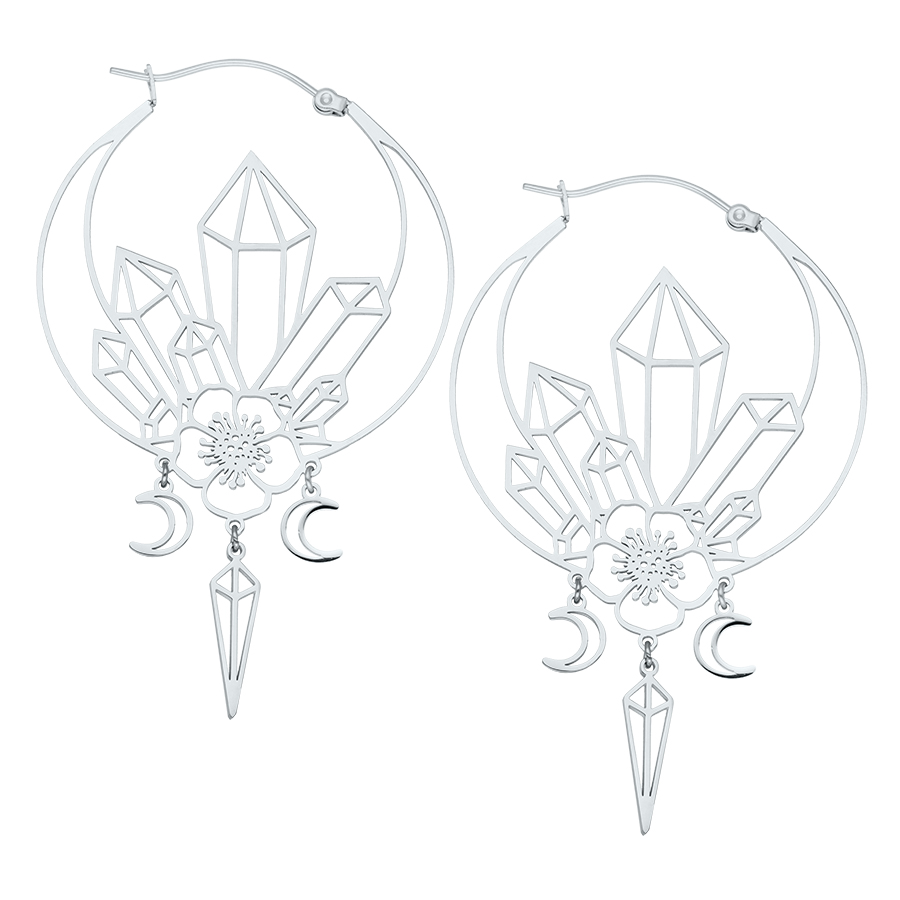 Silberne Ohrringe mit geometrischen Kristallmotiven und Mondanhängern auf weißem Hintergrund