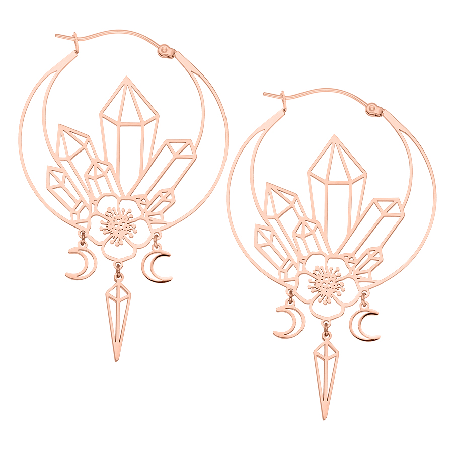 Roségoldene Ohrringe mit geometrischen Kristall- und Mondanhängern auf weißem Hintergrund