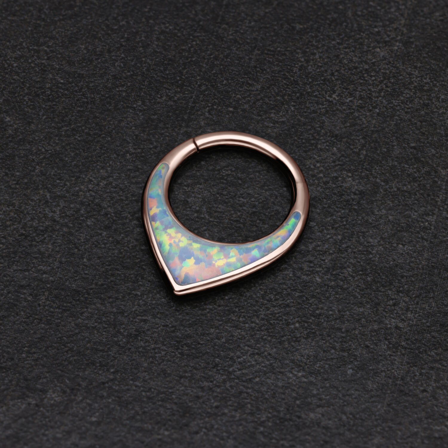 Ruusuinen septum-klickeri synteettisellä opaalilla mustalla taustalla