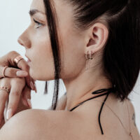 Nainen ruusukultaisella Helix-lävistyksellä, ketjumalli, sivuprofiili