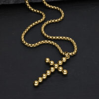 Goldene Kreuzkette aus Kugeln auf schwarzem Hintergrund