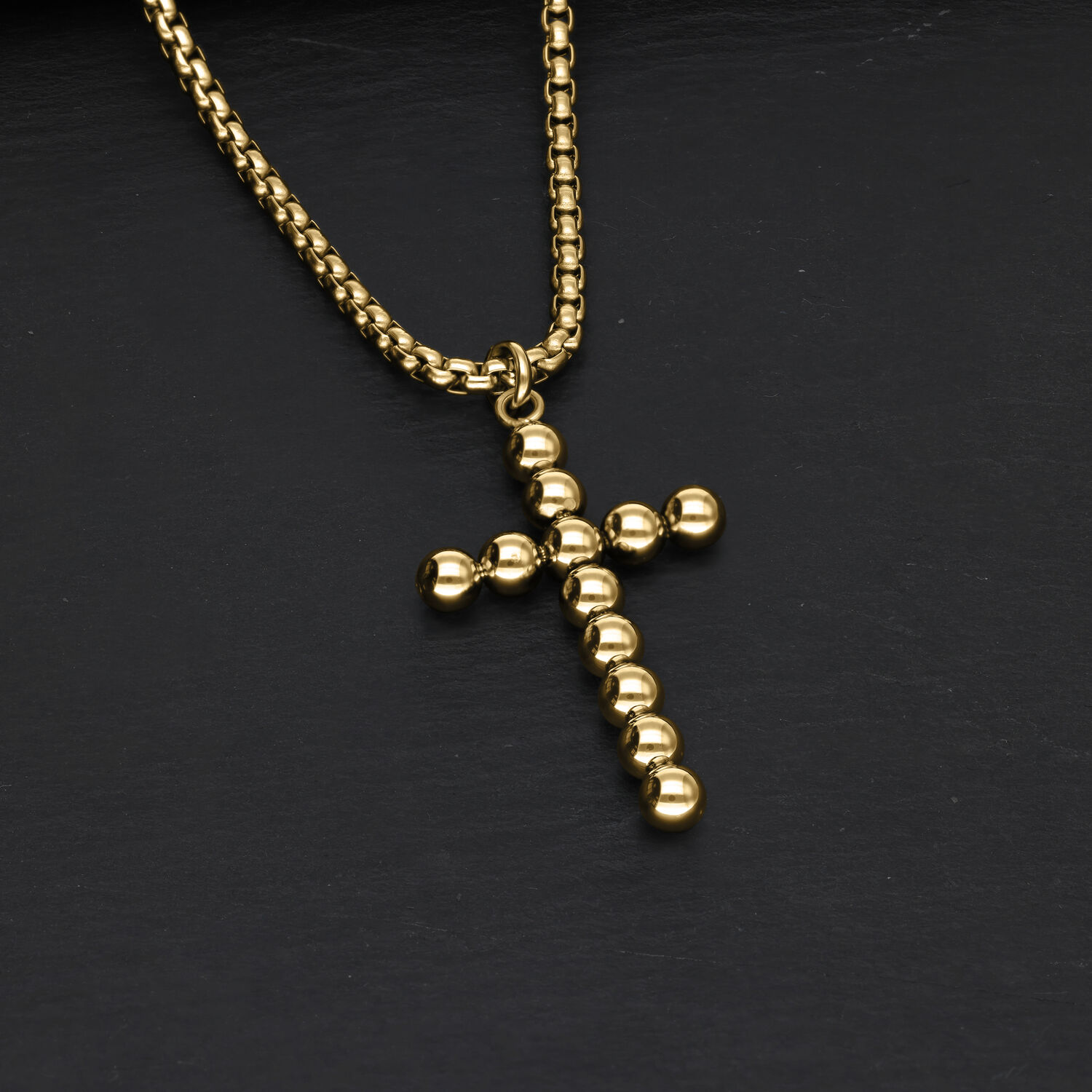 Goldene Bubble Cross Halskette aus Chirurgenstahl auf schwarzem Hintergrund