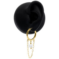 Goldene Ohrringe mit Kette und weißem Stein auf einem schwarzen Hintergrund