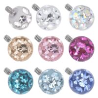 Neun runde, mehrfarbige Aufsätze mit Kristallen auf weißem Hintergrund