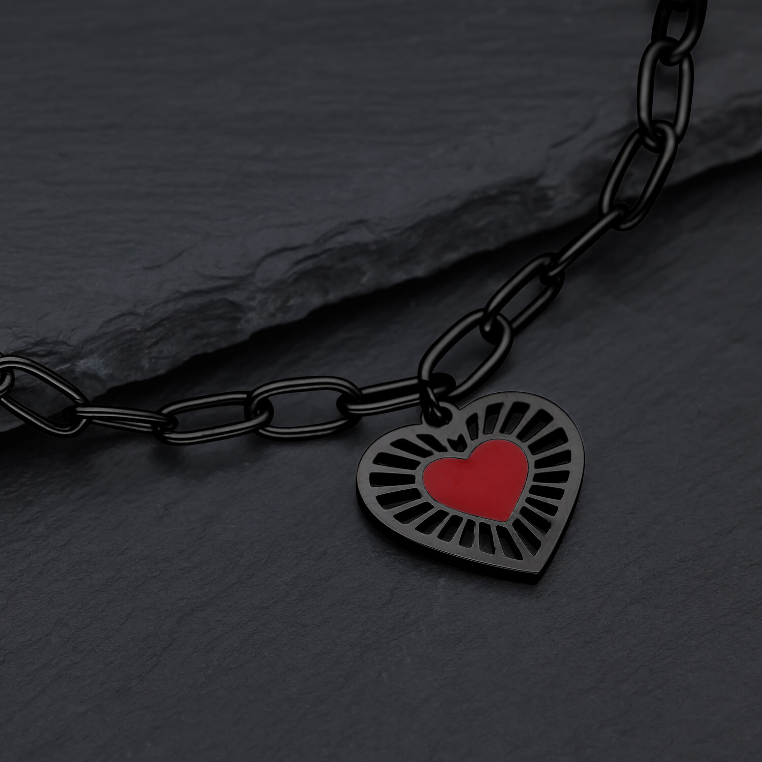 Schwarzes Herzarmband aus Chirurgenstahl Schwarzes Armband mit rotem Herzanhänger auf dunklem Hintergrund