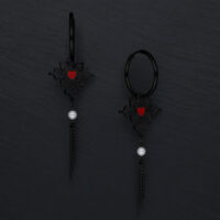 Schwarze Ohrringe mit rotem Herz und Kettenanhänger auf dunklem Hintergrund