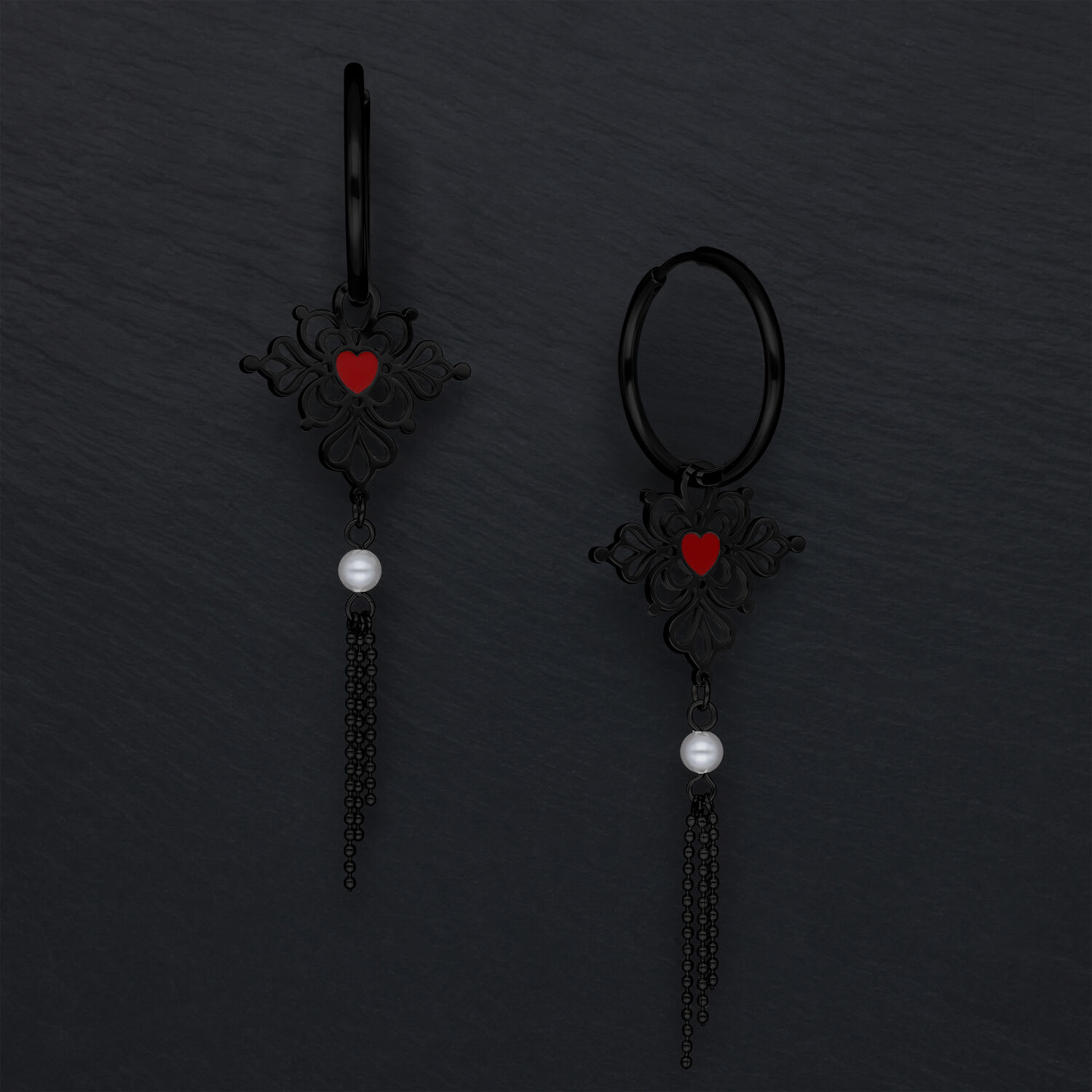 Schwarze Ohrringe mit rotem Herz und Kettenanhänger auf dunklem Hintergrund