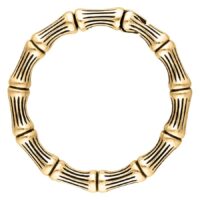 Pyöreä korvapaino kultaisesta kirurginteräksestä luurankokuvioinnilla valkoisella taustalla