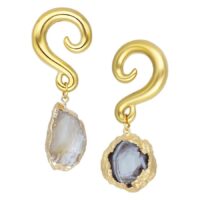 Kaksi kultaista intialaista akaatti korvakorua luonnonkivellä valkoisella taustalla